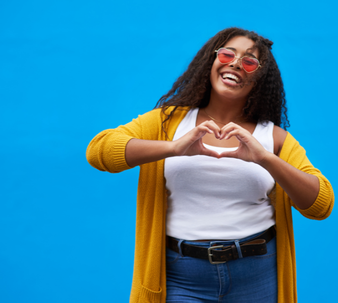 Love Your Voice A woman holding her fingers in the shape of a heart.